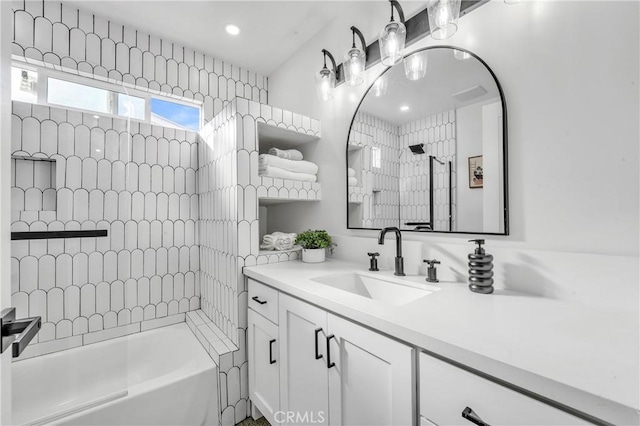 bathroom featuring vanity and tiled shower / bath