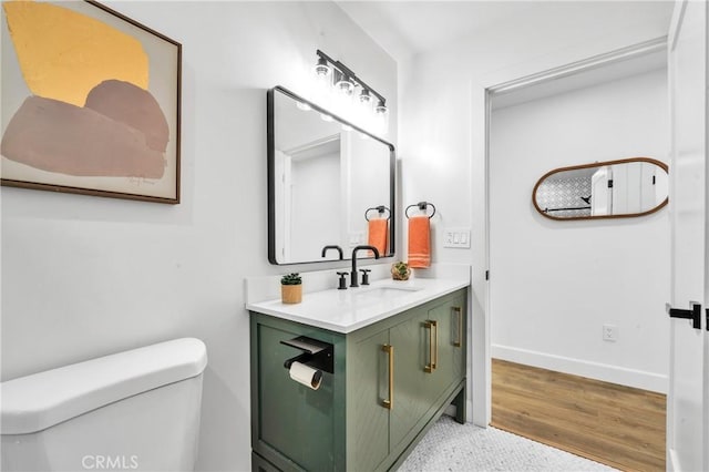 bathroom with hardwood / wood-style floors, vanity, and toilet