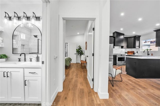 interior space featuring decorative backsplash, vanity, and hardwood / wood-style flooring