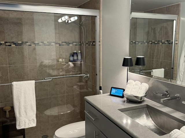 bathroom featuring walk in shower, vanity, and toilet