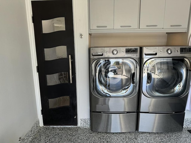 washroom featuring cabinets and separate washer and dryer