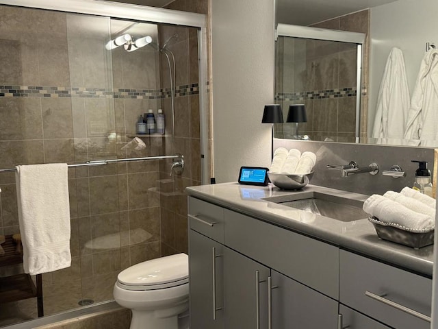 bathroom with toilet, vanity, and an enclosed shower