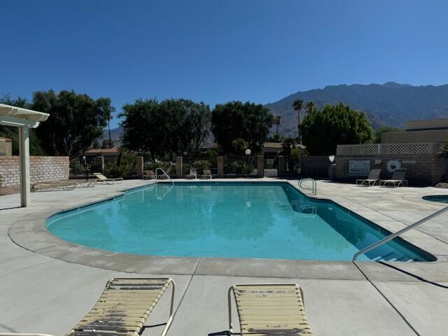 view of pool with a mountain view and a patio area