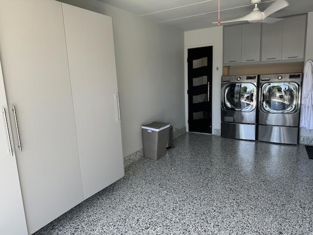 laundry area with ceiling fan, washing machine and clothes dryer, and cabinets