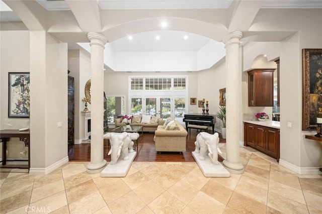 interior space with crown molding, light tile patterned floors, and ornate columns