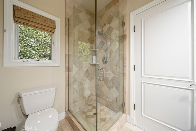 bathroom featuring walk in shower, tile patterned flooring, and toilet