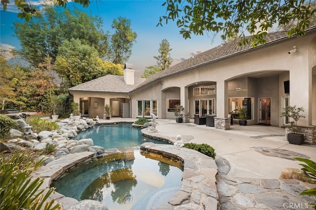 view of swimming pool featuring an in ground hot tub and a patio area