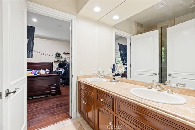 bathroom with walk in shower, wood-type flooring, and vanity