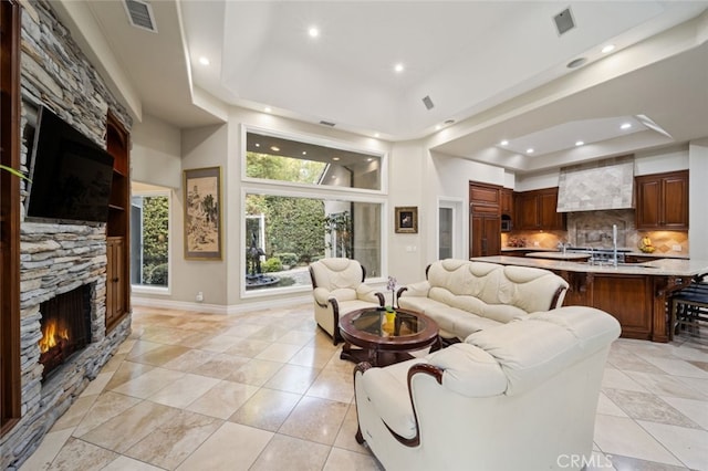 living room featuring a fireplace and a raised ceiling