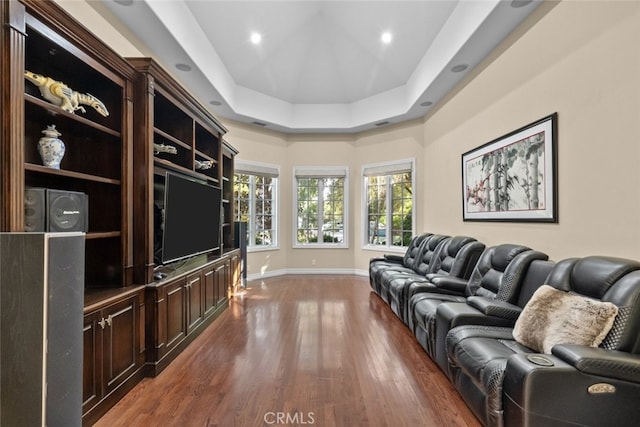 living room featuring a tray ceiling and dark hardwood / wood-style flooring