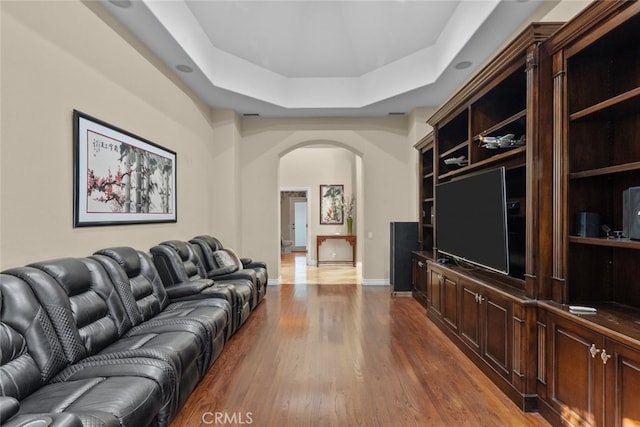 living room with a tray ceiling and hardwood / wood-style flooring