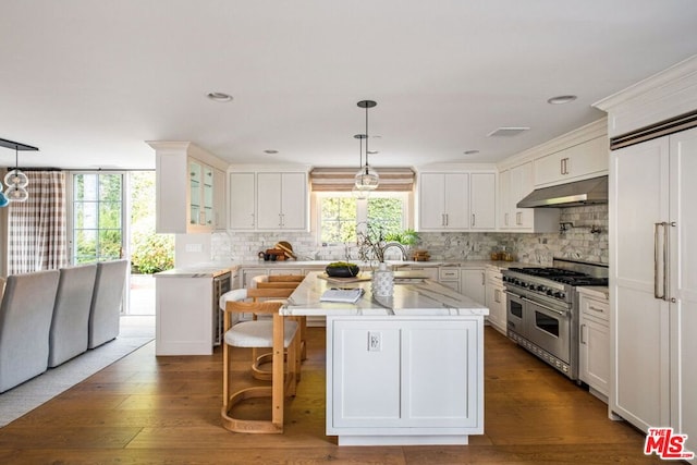 kitchen featuring white cabinets, dark hardwood / wood-style flooring, a kitchen island, and double oven range