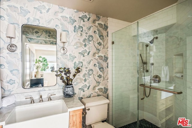 bathroom with vanity, toilet, and a shower with door