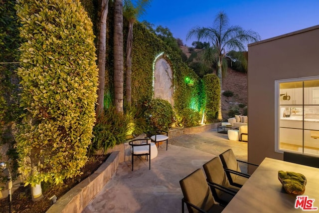 patio terrace at dusk featuring an outdoor hangout area