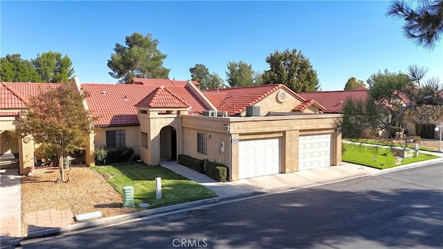 mediterranean / spanish-style home with a garage and a front lawn