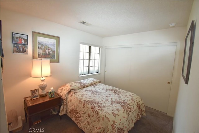 bedroom featuring dark colored carpet and a closet