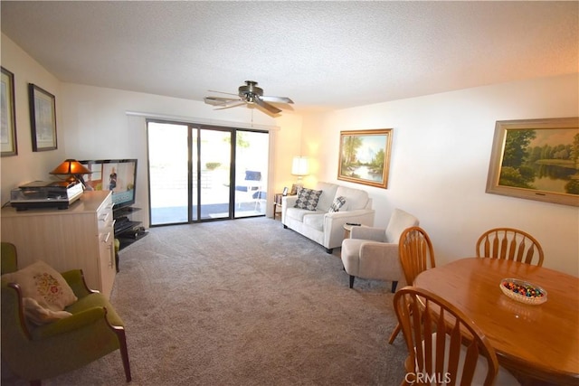 carpeted living room with ceiling fan and a textured ceiling