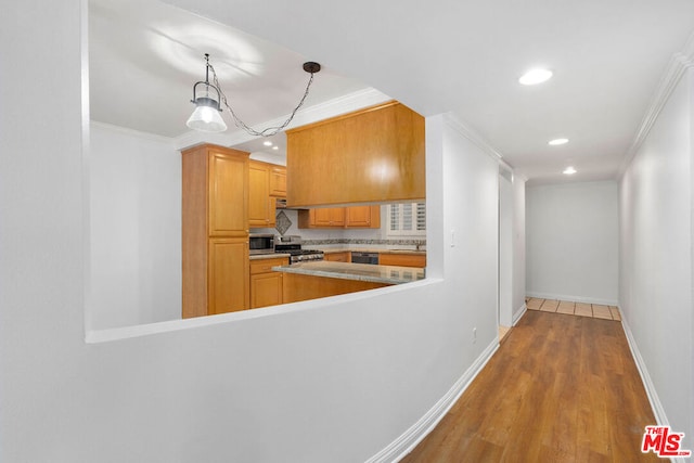 kitchen with stainless steel appliances, wood-type flooring, decorative light fixtures, and ornamental molding