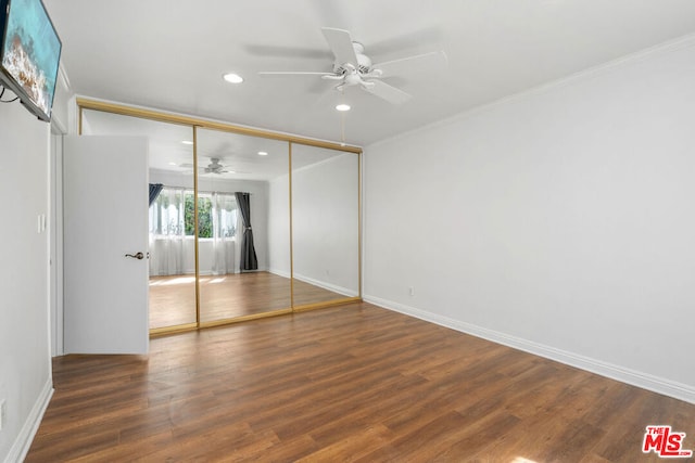 unfurnished bedroom with ceiling fan, a closet, dark wood-type flooring, and ornamental molding