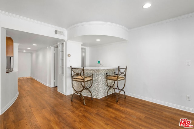 kitchen featuring hardwood / wood-style floors and crown molding