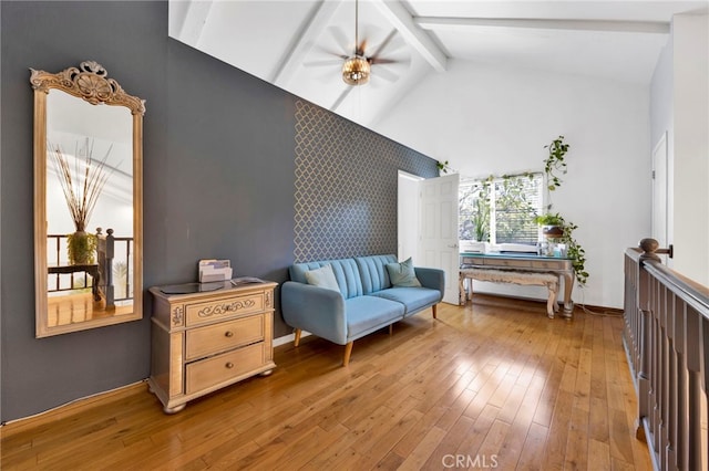 sitting room with wood-type flooring, ceiling fan, beamed ceiling, and high vaulted ceiling