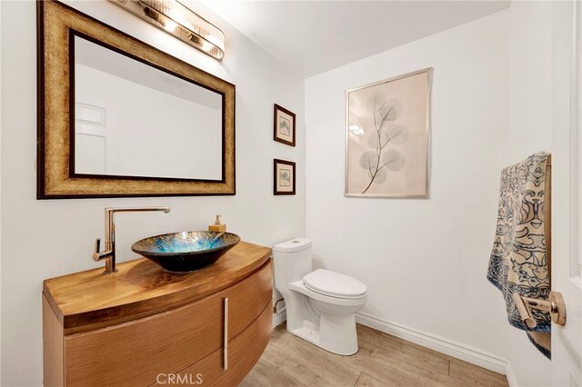 bathroom featuring hardwood / wood-style floors, vanity, and toilet