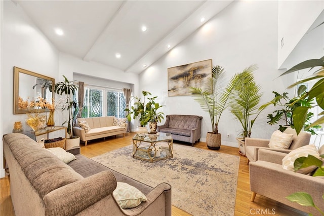 living room with beam ceiling, light hardwood / wood-style flooring, and high vaulted ceiling