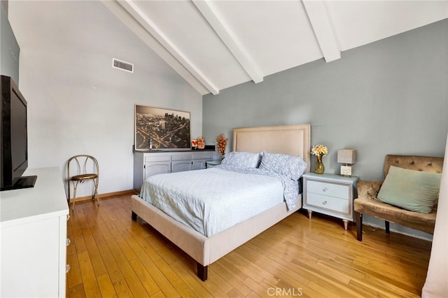 bedroom featuring light hardwood / wood-style floors, beamed ceiling, and high vaulted ceiling