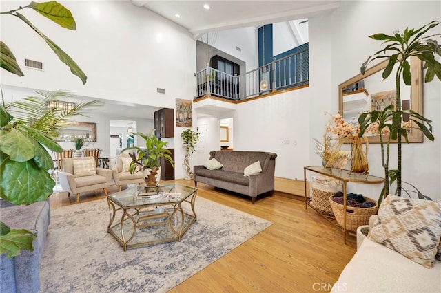 living room with high vaulted ceiling and light hardwood / wood-style floors