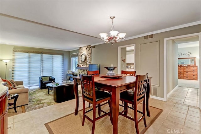 dining space featuring light tile patterned floors, crown molding, and an inviting chandelier