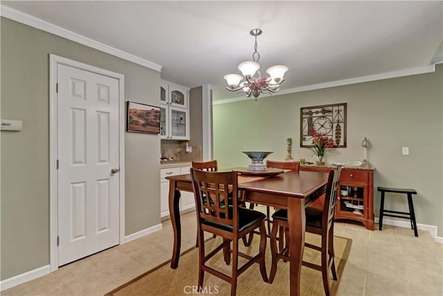 dining space with light tile patterned floors, ornamental molding, and a notable chandelier