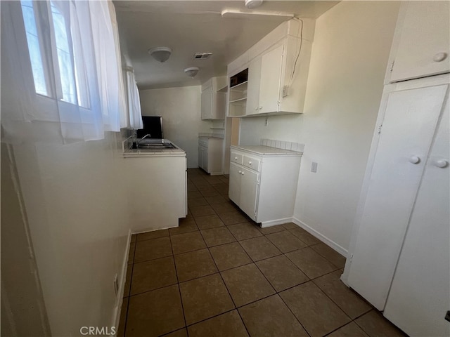 washroom with sink and dark tile patterned floors