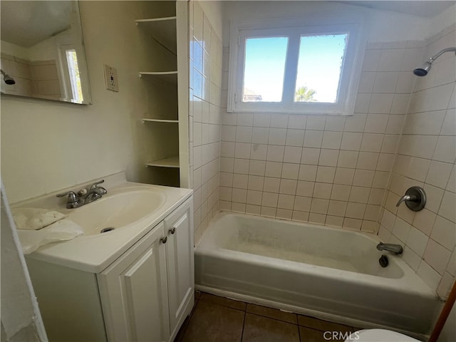 full bathroom featuring tile patterned floors, tiled shower / bath, vanity, and toilet