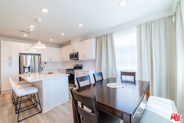 dining space featuring sink and light hardwood / wood-style flooring