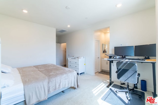 bedroom with light carpet and connected bathroom