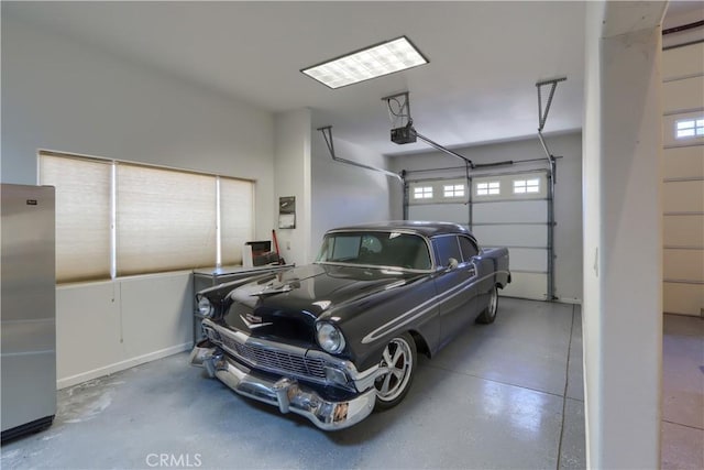 garage featuring stainless steel refrigerator and a garage door opener