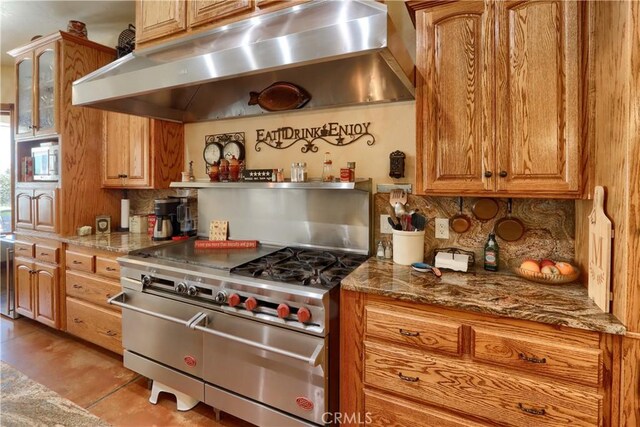 kitchen with double oven range, tasteful backsplash, under cabinet range hood, and stone countertops