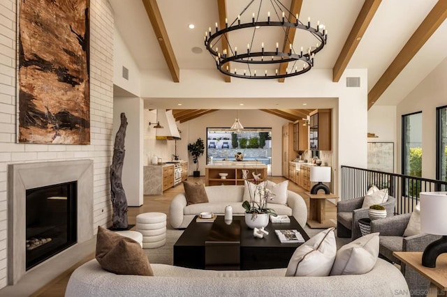 living room featuring beam ceiling, an inviting chandelier, light hardwood / wood-style flooring, and high vaulted ceiling