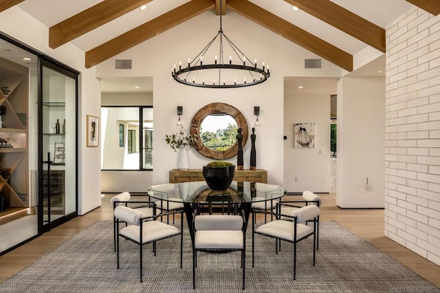 dining room with an inviting chandelier, beam ceiling, hardwood / wood-style floors, and high vaulted ceiling