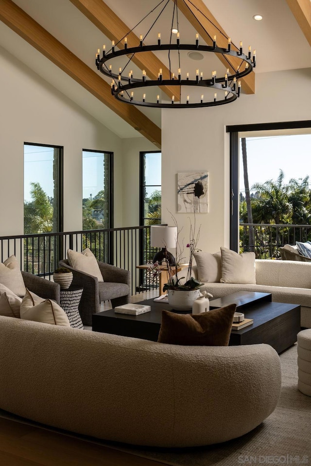 living room with beamed ceiling, a notable chandelier, hardwood / wood-style floors, and a wealth of natural light