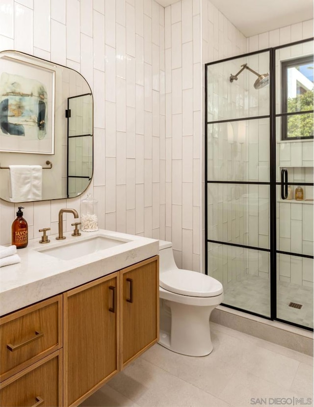 bathroom with tile walls, an enclosed shower, vanity, and toilet