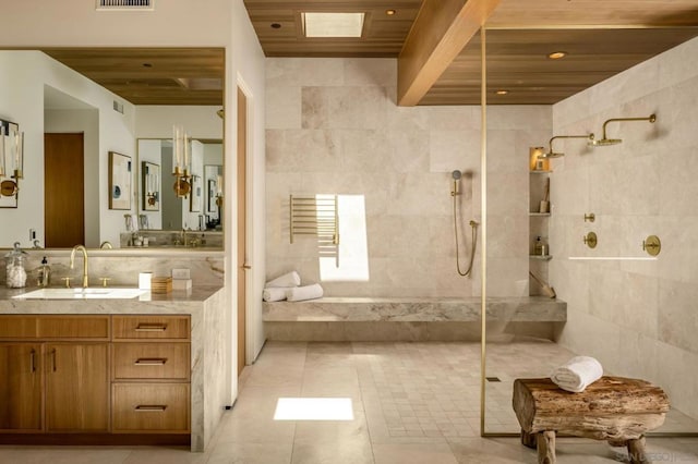 bathroom with a tile shower, tile walls, tile patterned flooring, wooden ceiling, and vanity