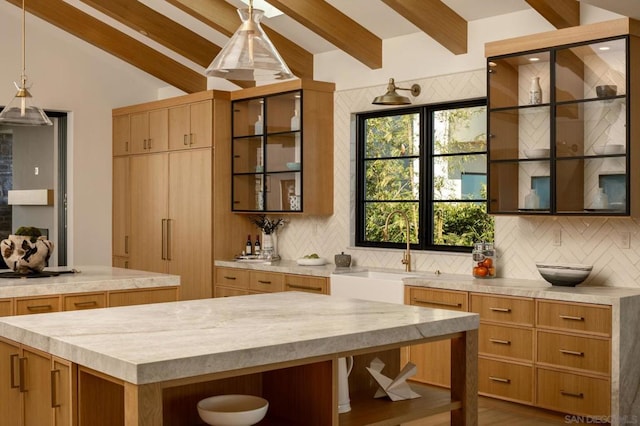 kitchen with decorative backsplash, vaulted ceiling with beams, a center island, and sink