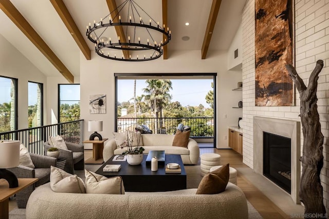 living room featuring high vaulted ceiling, a fireplace, beamed ceiling, wood-type flooring, and a notable chandelier