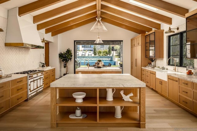 kitchen with light hardwood / wood-style flooring, sink, decorative backsplash, and a kitchen island