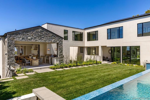 rear view of house with a lawn, a patio, and outdoor lounge area