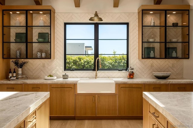 kitchen featuring light hardwood / wood-style floors, sink, and tasteful backsplash