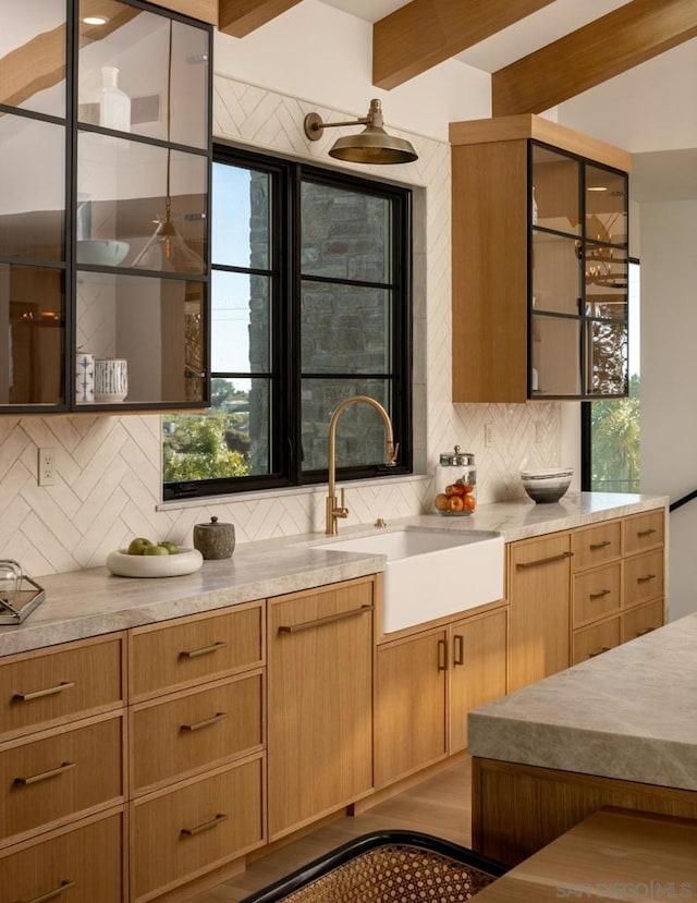 kitchen featuring decorative backsplash, beam ceiling, hardwood / wood-style flooring, and sink