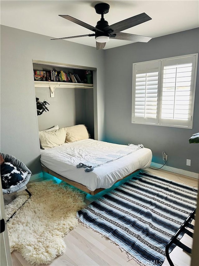 bedroom featuring ceiling fan, wood-type flooring, and a closet