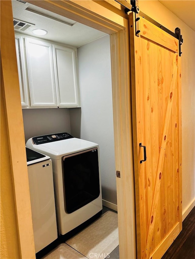 washroom featuring cabinets, a barn door, and separate washer and dryer